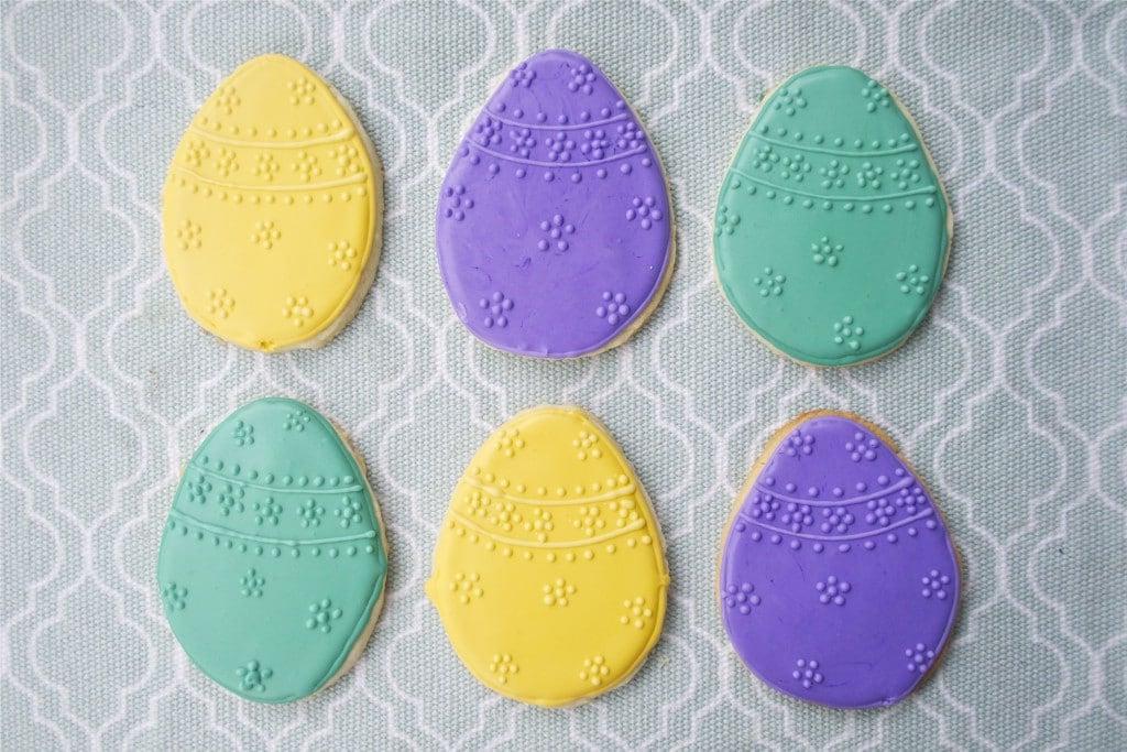 Sugar cookies decorated with green, yellow and purple royal icing to look like Easter eggs. 