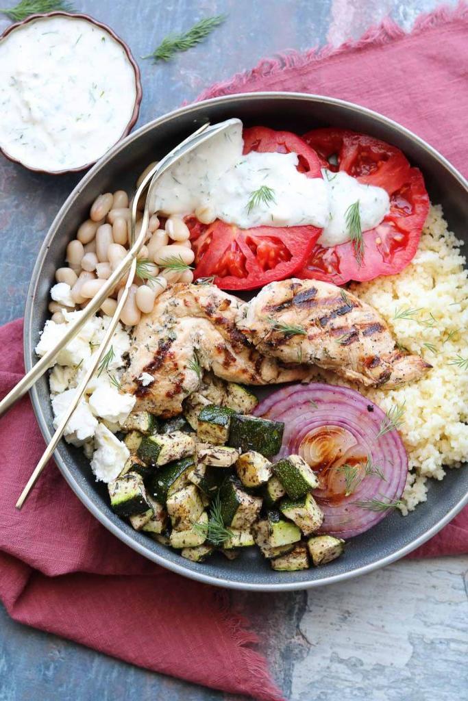bowl with grilled chicken vegetables with yogurt dill dressing on napkin