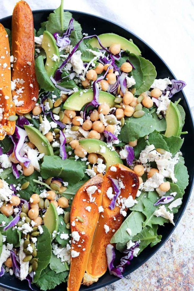 colorful superfood spinach salad on plate garnished with roasted squash
