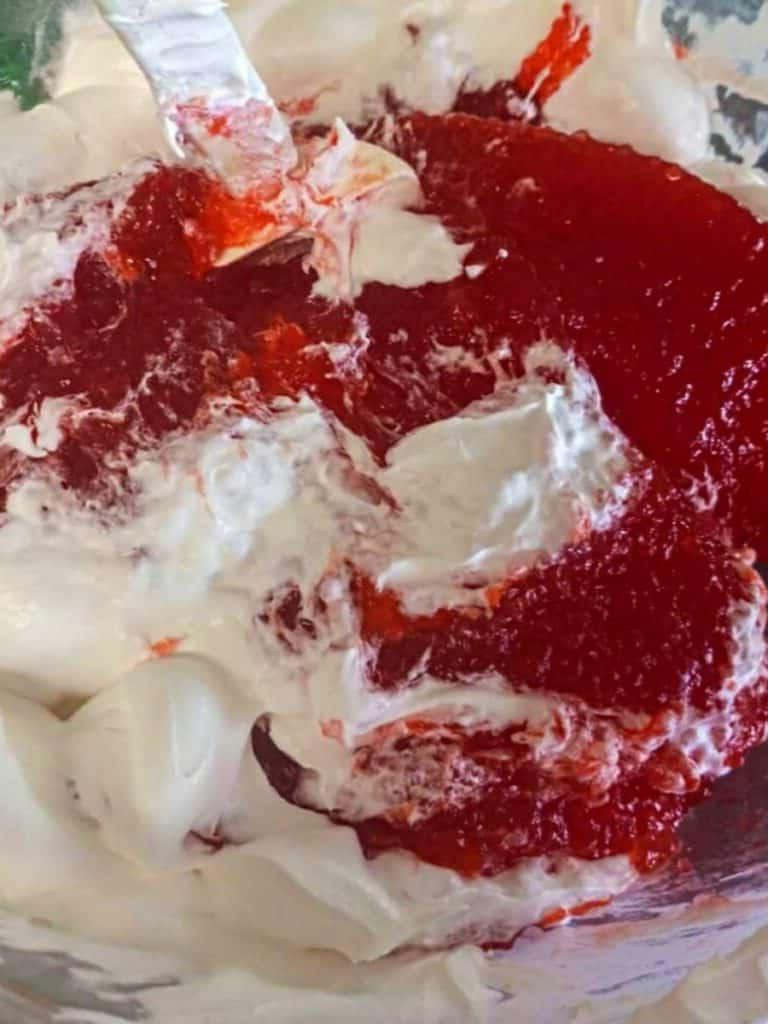 mixing Cool Whip with the tapioca mixture.